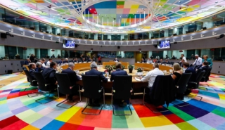 De leden van de Europese raad vergaderen aan een ronde tafel.