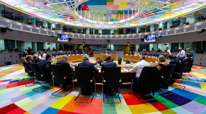 De leden van de Europese raad vergaderen aan een ronde tafel.