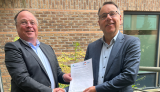 Directeur Vewin en directeur Energie Nederland schudden hand en houden ondertekend contract vast